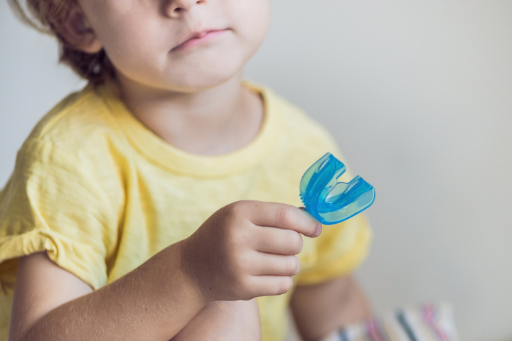 マイオブレースのマウスピースを手にする子ども