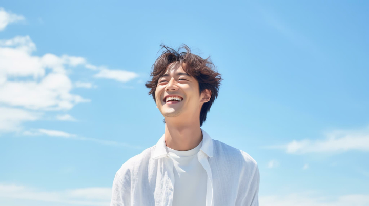 青空の下で笑顔の男性