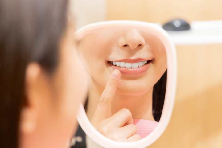 白い歯を鏡で確認する女性