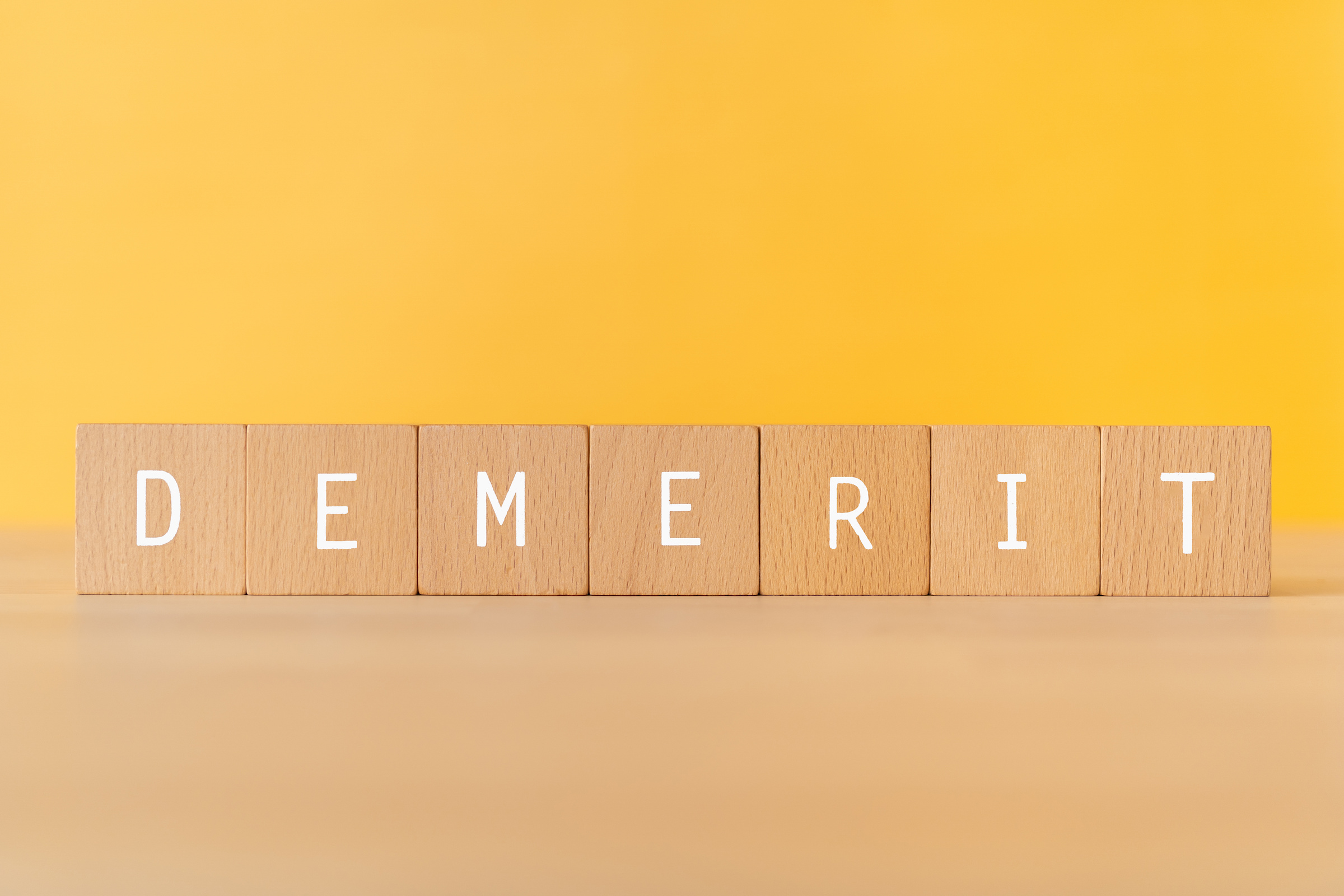 「DEMERIT」と書かれた積み木