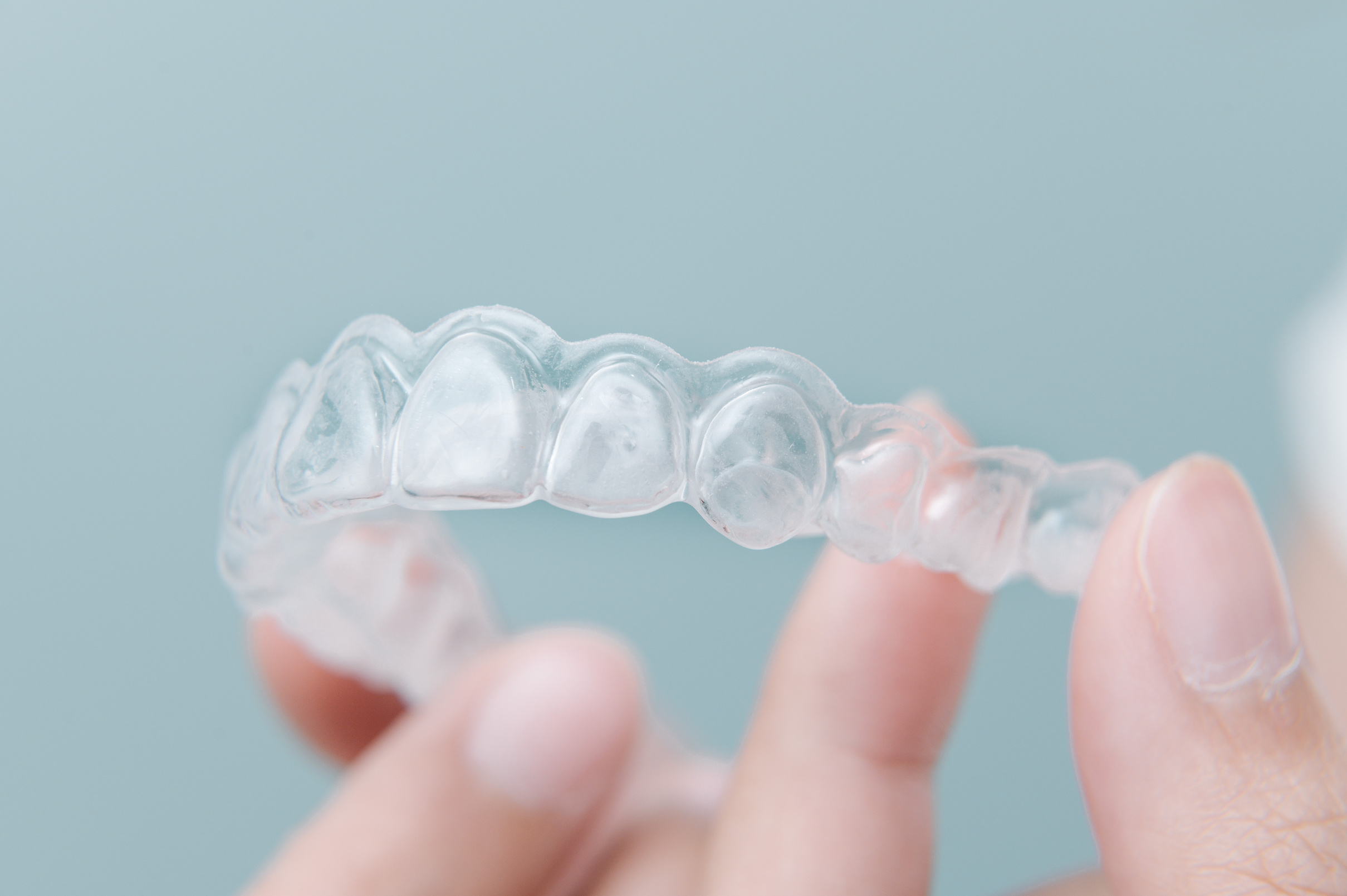 Transparent dental orthodontics to correct dental alignment on hand.