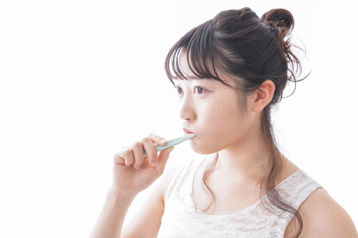 奥歯が虫歯になるのを防ぐために丁寧にブラッシングしている女性