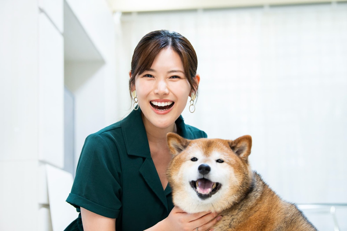 歯の矯正で整った歯並びになった笑顔の女性と愛犬